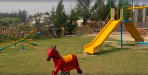 a playground with a toy horse and a slide at Arya Beach resort in Mandarmoni