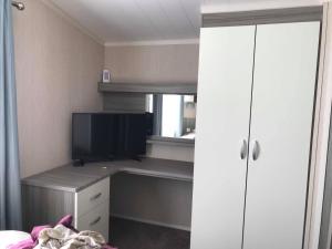 a bedroom with a desk with a tv on it at Lime crescent golden sands in Mablethorpe