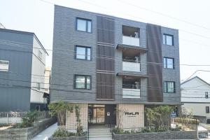 een groot bakstenen gebouw met een zwarte bij ReLA Higashimatsudo in Matsudo