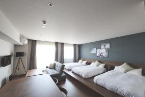 a hotel room with two beds and a couch at ReLA Higashimatsudo in Matsudo