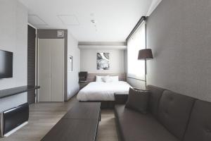 a hotel room with a bed and a couch at ReLA Higashimatsudo in Matsudo