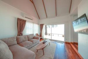 ein Wohnzimmer mit Couch und Flachbildfernseher in der Unterkunft Twin Bay Resort Koh Lanta in Ko Lanta