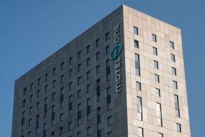 a tall building with a clock on the top of it at Motel One Hamburg-Alster in Hamburg