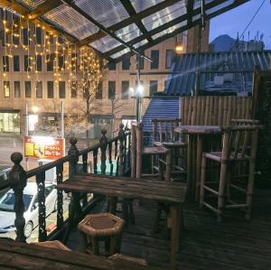 a wooden bench sitting on a balcony with lights at Worldtreck Dinner & Guesthouse Pise in Nagano