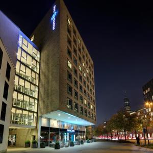 
a tall building with a clock on the front of it at Motel One Hamburg am Michel in Hamburg

