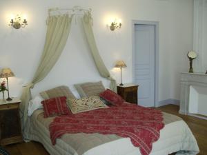 1 dormitorio con 1 cama con manta roja en DOMAINE DE BERTHEGILLE, en Sablonceaux