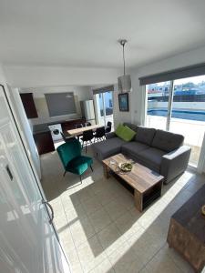 ein Wohnzimmer mit einem Sofa und einem Tisch in der Unterkunft Cosy apartment in Kato Paphos with pool access in Paphos City