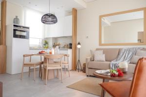 a living room and kitchen with a couch and a table at U-Sense Sevilla Catedral in Seville