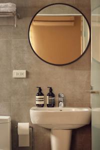 un bagno con lavandino e specchio di Sunlight Homestay a Magong
