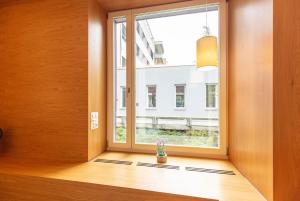 ein Fenster in einem Zimmer mit einer Vase auf dem Boden in der Unterkunft Hotel & Lounge by Hyve Basel SBB in Basel