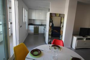 cocina y comedor con mesa y sillas en 0705 Ap Victoria I en Dénia