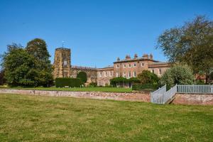 a large building with a clock tower in the background at Thirsk Hall South Wing, North Yorkshire in Thirsk