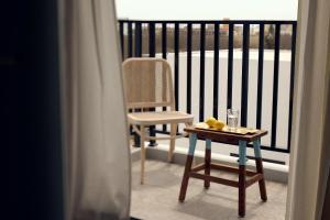 馬公市にあるSunlight Homestayのバルコニー(椅子、ガラス張りのテーブル付)