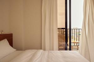 1 dormitorio con cama y vistas a un balcón en Sunlight Homestay, en Magong
