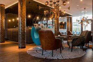 a dining room with chairs and a bar at Motel One München-Westend in Munich