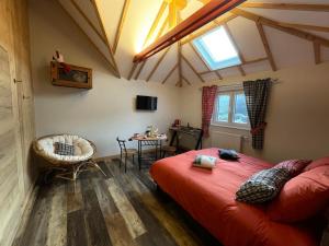 Un dormitorio con una gran cama roja y una ventana en Le Refuge du Rempart, en Dambach-la-Ville