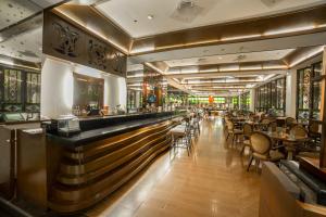 a restaurant with a bar and tables and chairs at Waterfront Airport Hotel and Casino in Mactan