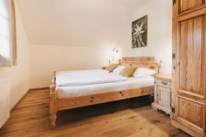 Latschach ober dem Faakerseeにあるナチュレル　ホテルドルフ　シューンライン のベッドルーム1室(木製ベッド1台、木製ドレッサー付)