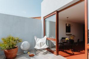 a patio with a white chair and a table at THE MODERNIST, Architecture experience in Faro