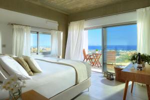 a bedroom with a large bed with a view of the ocean at Cottage Kokkini Hani in Kokkini Khanion