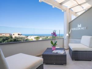 a balcony with a couch and a table at Horizon Hotel Badesi in Badesi