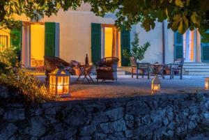 a patio with a table and chairs with lights at agriturismo la selva in Finale Ligure