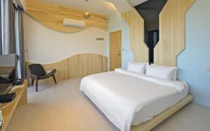 a bedroom with a large white bed and a chair at Sunny Stream B & B in Wujie