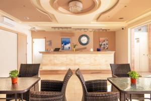 a restaurant with tables and chairs and a clock on the ceiling at Pleasure Beach Hotel in Malia