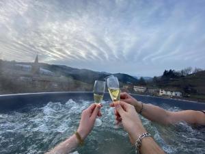 two people holding wine glasses in a bath tub at Domaine de la Rue de la Tour in Valsonne