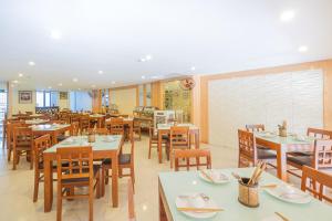 uma sala de jantar com mesas e cadeiras e sem intenção em Hoa Phong Airport Danang Hotel em Da Nang