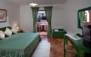 Schlafzimmer mit einem Bett, einem Tisch und einem Fenster in der Unterkunft Residence Sos Alinos in Cala Liberotto