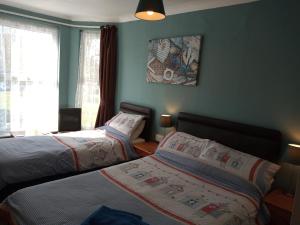 A bed or beds in a room at Sandcastles Guest House 