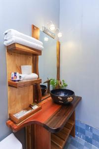 bagno con bancone in legno, lavandino e specchio di KoiKing Homestay Quy Nhơn a Quy Nhon