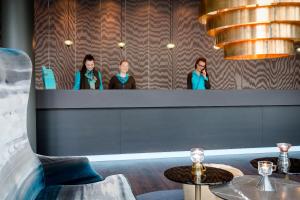 a group of people standing behind a counter in a restaurant at Motel One München Sendlinger Tor in Munich