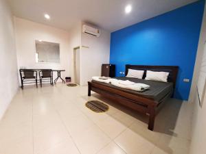 une chambre avec un lit et un mur bleu dans l'établissement Tongmai Resort, à Surat Thani 21 autres photos