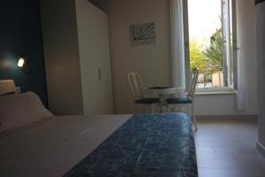 a bedroom with a bed and a table and a window at Rooms Il Punto in Peschiera del Garda