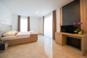 1 dormitorio con 1 cama y TV de pantalla plana en HOTEL BARON en Smlednik