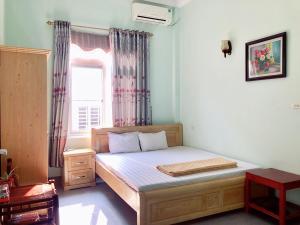 a bedroom with a large bed with a window at I Love Coto Hai Au Hotel is central near beach in Đảo Cô Tô