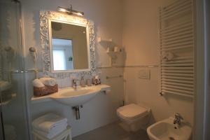 a bathroom with a sink and a toilet and a mirror at Rooms Il Punto in Peschiera del Garda