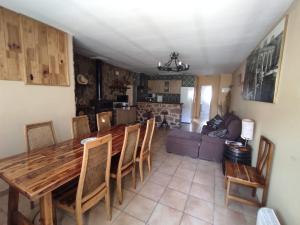 cocina y sala de estar con mesa de madera y sillas en Casa Rural El Olmo, en Alobras