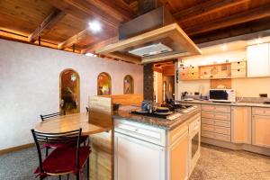 a kitchen with a wooden table and a counter top at L'Atelier du Temps - Woodstone Villa in Aosta