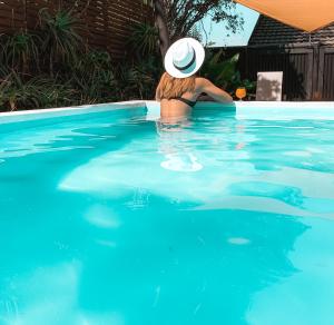a woman in a hat in a swimming pool at Lush in Graskop