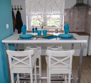a kitchen with a table with two white stools at Urban House - Ada in Ada