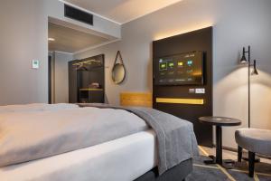 a hotel room with a bed and a tv at the niu Fury - Apartments in Aschheim