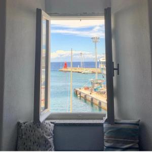 una finestra con vista sull'oceano e su un molo di Occhio sul mare a Giglio Porto