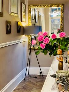 una habitación con un jarrón de rosas rosas en The Westbank, en Torquay