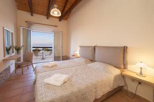 a bedroom with a bed and a view of the ocean at Zephyros Hotel in Skala