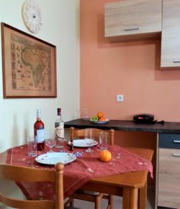 eine Küche mit einem Tisch und Gläsern Wein in der Unterkunft Afrodite Lefkimmi Apartment 1 in Lefkímmi