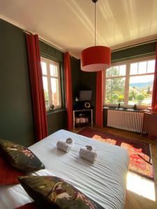 a bedroom with a bed with two towels on it at LA VILLA Hôtel-Restaurant in Saverne