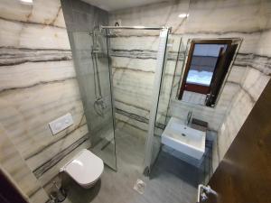 y baño con ducha, aseo y lavamanos. en Hotel Oferta en Prizren